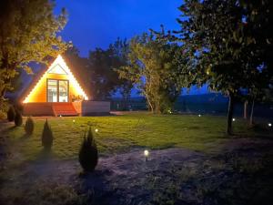 a cabin in a field at night with lights at Fecske Kabin in Szólád