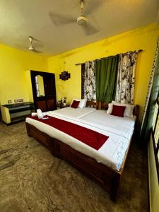 una camera con un grande letto in una camera gialla di La Beach Resort Muthu a Pondicherry