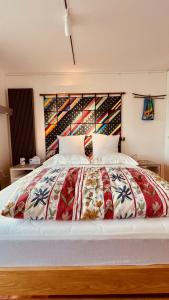 a large bed with a colorful comforter in a bedroom at The Bolthole - Charteris Bay Holiday Home in  Lyttelton