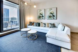 a living room with a couch and two tables at Sparkle Tower, Dubai Marina in Dubai
