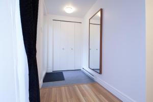 a hallway with a mirror and white walls at Le 2662 Charlemagne in Montréal