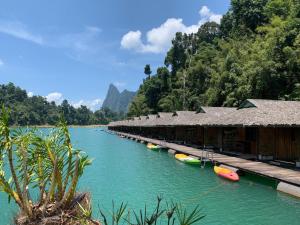 una larga hilera de edificios en un río en PraiwanRaftHouse แพไพรวัลย์, en Ban Wang Khon