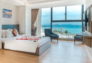 a bedroom with a bed and a view of the ocean at Areca Hotel Nha Trang in Nha Trang