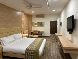 ein Hotelzimmer mit einem Bett und einem Fernseher in der Unterkunft Heritage Residency By Lemongrove Hospitality in Madurai