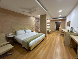 a bedroom with a bed and a couch and a desk at Heritage Residency By Lemongrove Hospitality in Madurai