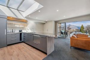 an open kitchen with a view of the mountains at Walter Peak View Apartment in Queenstown