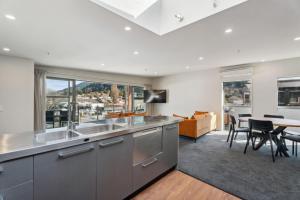 a kitchen with stainless steel appliances and a dining room at Walter Peak View Apartment in Queenstown +15 photos