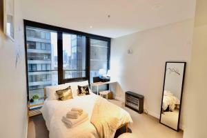 a bedroom with a bed and a large window at Entire 1 BR Southbank Apartment - Gym Pool Sauna 1 step to Crown Casino in Melbourne +64 photos
