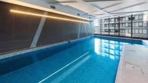 a large swimming pool in a building with a building at Entire 1 BR Southbank Apartment - Gym Pool Sauna 1 step to Crown Casino in Melbourne