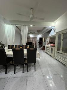 シャー・アラムにあるMael's Homestay Seksyen 16 Shah Alamのテーブルと椅子のあるリビングルーム +9枚の写真