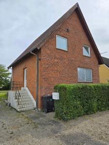 a brick house with a trash can in front of it at Cozy Townhouse Near Beach, Harbor, And Lalandia in Rødby