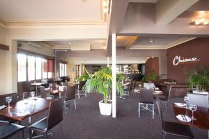 a restaurant with tables and chairs and plants at Hotel Northbridge in Perth
