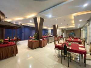 a restaurant with red tables and chairs in a room at Grand mansion hotel in Blitar