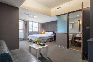 a hotel room with a bed and a couch at The Galerie Hotel in Taichung