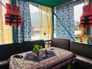a table and chairs with a table and a window at H.B Rocket paradise in Srinagar