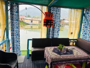 a room with a couch and a table and a window at H.B Rocket paradise in Srinagar