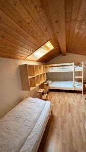 a bedroom with two bunk beds and a wooden ceiling at Chesa Panorama in Celerina