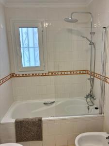 a bathroom with a tub and a window and a sink at Casa Leone in het hart van Villamartin in Villamartin
