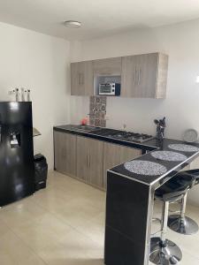 a kitchen with a black refrigerator and a counter at Apartamento en Las Mercedes tipo Loft in Palmira
