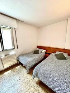 a bedroom with two beds and a window at Espacioso piso en Puertollano in Puertollano