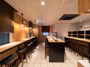a restaurant with a bar and stools at Super Hotel Ueno-Okachimachi in Tokyo