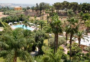 アグリジェントにあるホテル デラ ヴァッレのプールとヤシの木があるリゾートの空中ビュー