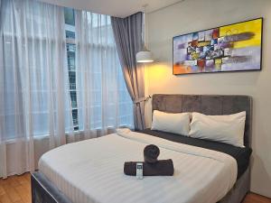 a bedroom with a bed with a hat on it at Apartment Sky by MonoSuites KLCC in Kuala Lumpur