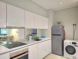 a kitchen with white cabinets and a refrigerator at Apartment Sky by MonoSuites KLCC in Kuala Lumpur