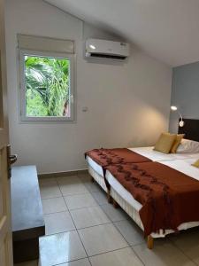 ein Schlafzimmer mit einem Bett und einem Fenster in der Unterkunft corail vert in La Saline Les hauts  + 14 Fotos