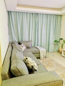 a living room with a couch with pillows on it at The Classy West End 1 bed with sleeper couch in Midrand