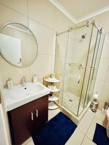 a bathroom with a sink and a shower at The Classy West End 1 bed with sleeper couch in Midrand +6 photos