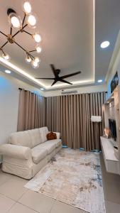 a living room with a white couch and a ceiling fan at Inara Homestay in Kuala Lumpur