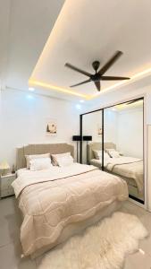 a bedroom with a large bed with a ceiling fan at Inara Homestay in Kuala Lumpur
