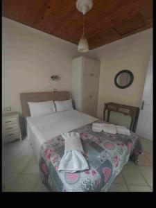 a bedroom with a bed with two towels on it at MARINA in Perama