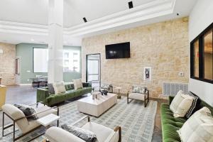 a living room with furniture and a stone wall at Sleeps 8 2B near Legacy West Toyota & The Star 2250 in Frisco