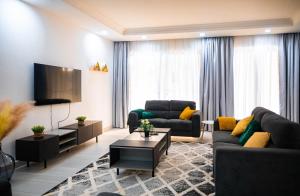 a living room with two couches and a tv at Amazing Junior Suite Space Available in Accra