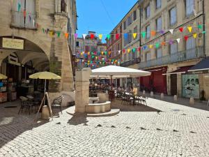 a city street with umbrellas and tables and chairs and buildings at Studio au cœur de Sommières in Sommières