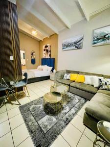 a living room with a couch and a bed at Stunning spacious Studio apartment in Sandton