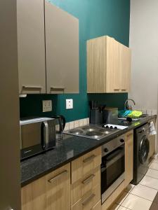 a kitchen with a stove and a microwave at Stunning spacious Studio apartment in Sandton