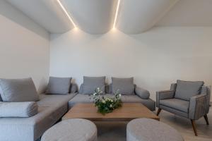 ArtCotel Luxury Villa في مدينة ريثيمنو: غرفة معيشة مع أريكة وكرسيين