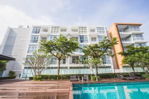 Haad Klong SonにあるAt Seacondo-1 Bedroom-A07のスイミングプールと木々のあるアパートメントビル