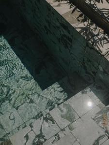 a shadow of a tree on a tiled floor at The Wild by Interni in Kalafatis