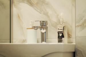 a bathroom sink with a mirror and a bottle of toothpaste at EFESA Apartments in Visoko +29 photos