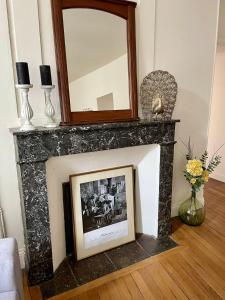 a fireplace with a mirror on top of it at La Villa Louana 3 Appartement 60m2 ,élégance et indépendance cœur de ville in Aubusson