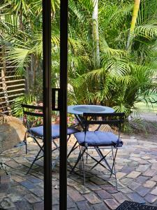 a table and two chairs sitting outside a window at The Garden House BnB in Barellan Point