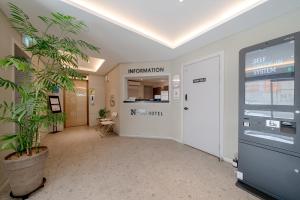 an office hallway with a door and a plant at No25 Hotel Jeonju Sanjeong in Jeonju