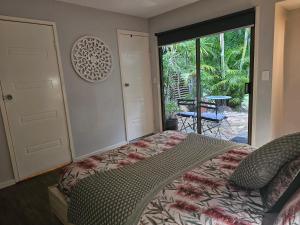 The Garden House BnB في Barellan Point: غرفة نوم بسرير وباب للباحة
