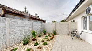 Un patio con plantas frente a una valla. en SALAN Apartman Sereď, en Seredʼ
