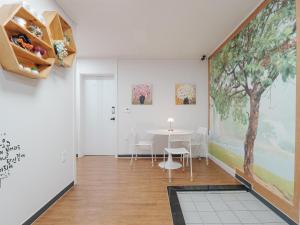 a dining room with a table and a large painting on the wall at 인천공항 게스트하우스 레인부츠 in Incheon