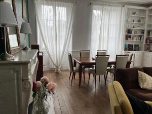a living room with a dining room table and chairs at La Villa Louana 2 Charme de l'ancien au cœur de ville in Aubusson